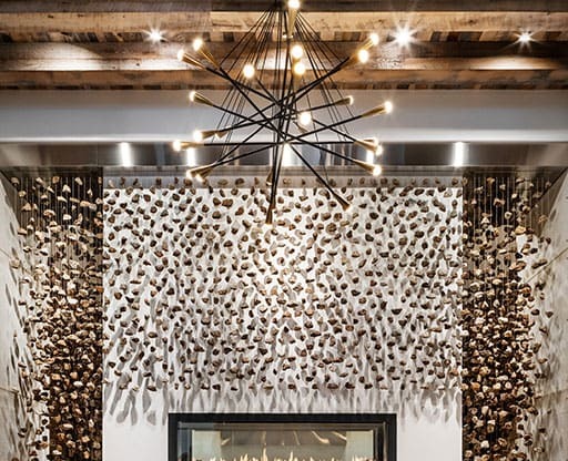 a living room with a fireplace and a wooden ceiling with a chandelier