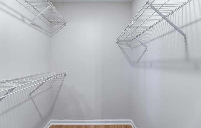 Empty silver shelves in a white room.