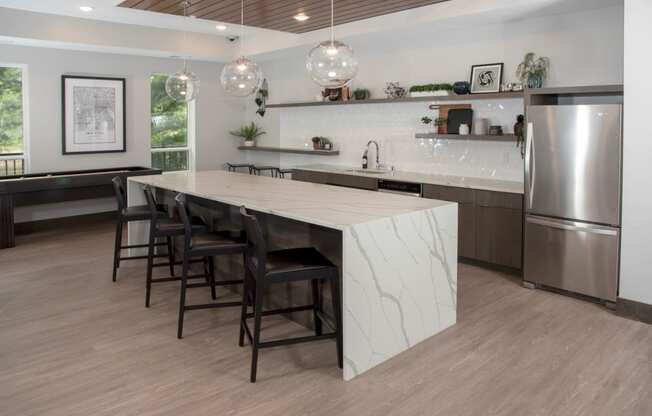 Community kitchen with bar seating and shuffleboard table at Urban Park I and II Apartments, St Louis Park, 55426