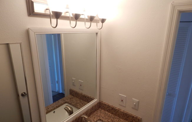 a white sink sitting under a mirror