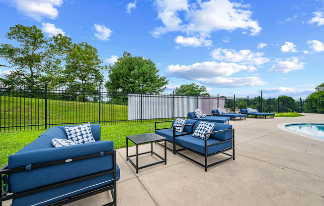 A blue sofa and a black coffee table are on a patio.