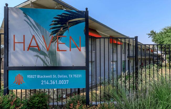 a sign in front of a fence