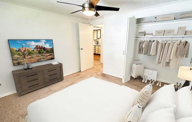 A living room with a white couch and a painting of a desert scene on the wall.