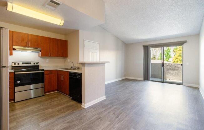 an empty kitchen and living room with a sliding glass door