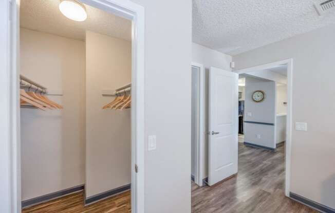 a hallway with a closet and a door to a room with a refrigerator