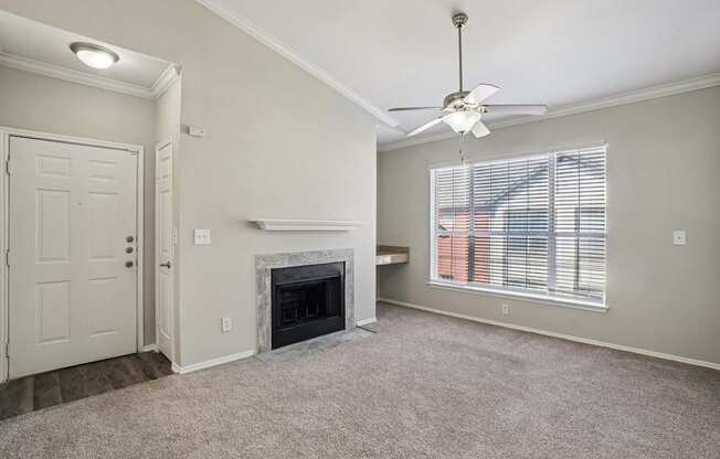 A living room with a fireplace and a ceiling fan.
