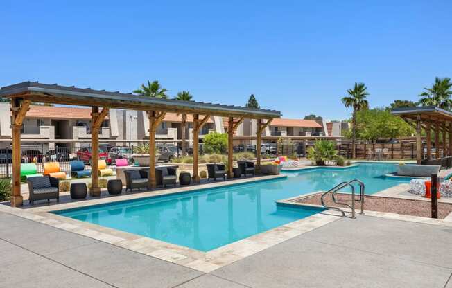 a swimming pool with lounge chairs and umbrellas at the retreat at thousand oaks apartments