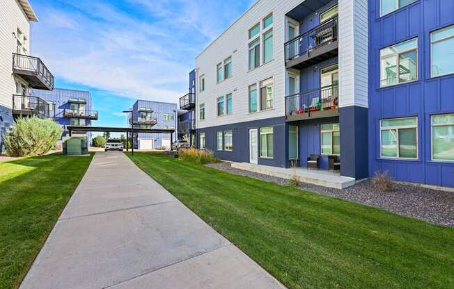 A long concrete walkway leads between two rows of modern townhouses.