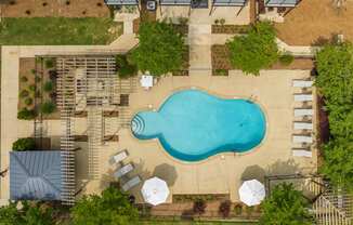 a birds eye view of a pool in a backyard with umbrellas