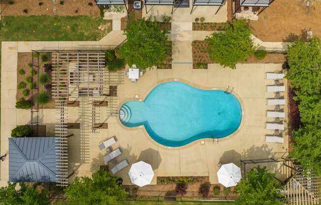 a birds eye view of a pool in a backyard with umbrellas