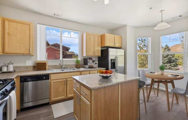 a kitchen with wooden cabinets and a table with a bowl of fruit