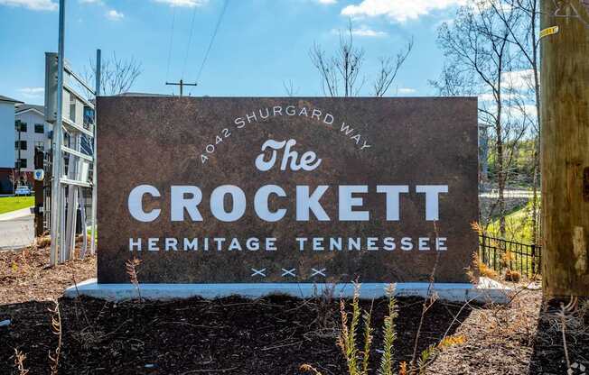 A brown sign with white lettering that says "The Crockett Hermitage Tennessee.".