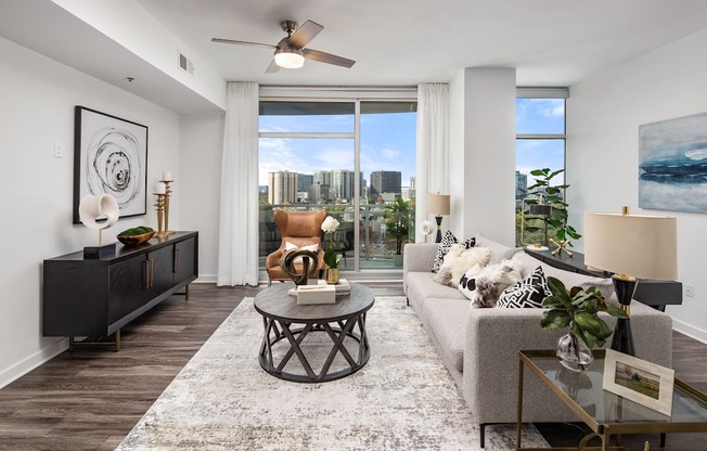 an open living room with a view of the city and a ceiling fan