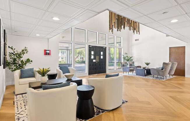 A modern living room with white furniture and a wooden floor.