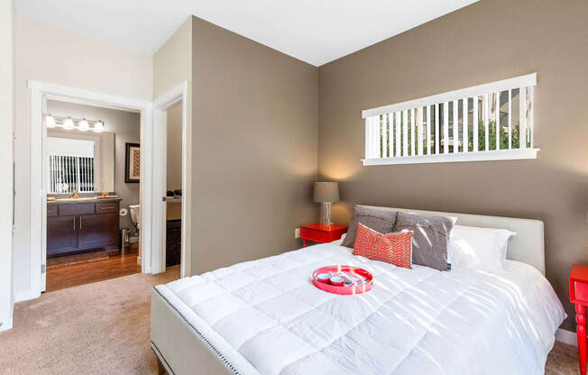 a bedroom with a large bed and a bathroom in the background at Mullan Reserve Apartments, Missoula, 59808