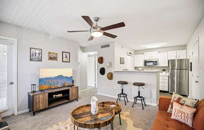 A living room with a brown coffee table and a painting on the wall.