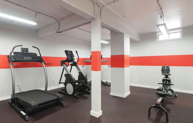 a gym with exercise equipment and a red stripe on the wall at The Packard, West Hartford, 06119