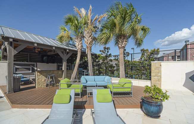 a patio with couches and chairs and palm trees