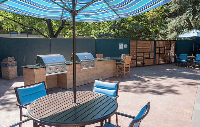 a patio with an umbrella and a table with chairs