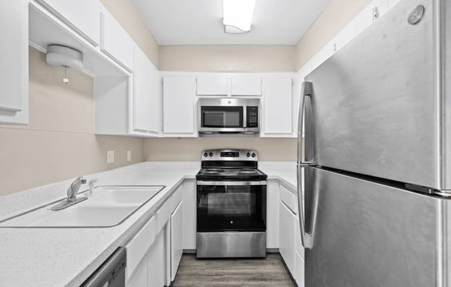 a white kitchen with stainless steel appliances and white cabinets at Diamond Ridge Townhomes, Oklahoma ,73114