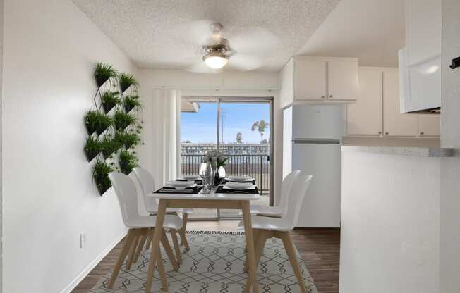 an open kitchen and dining room with a table and chairs and a balcony