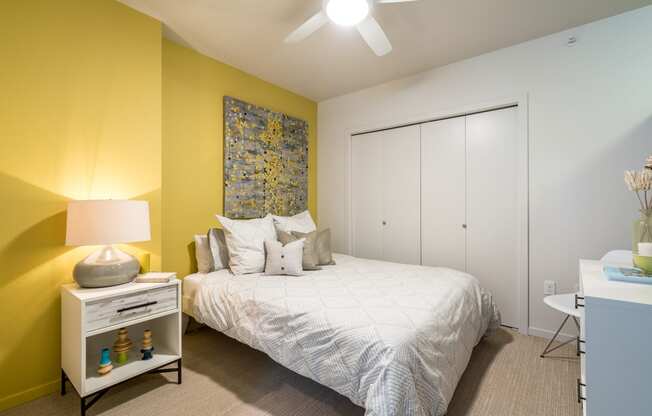 a bedroom with yellow walls and a white bed