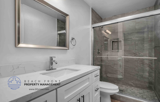 a bathroom with a white sink and toilet next to a shower with a glass door