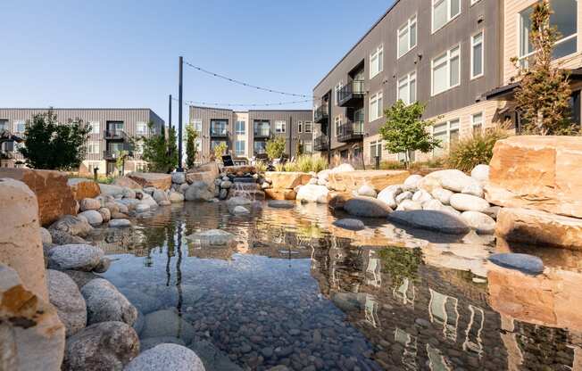 a water feature sits in front of a row of buildings