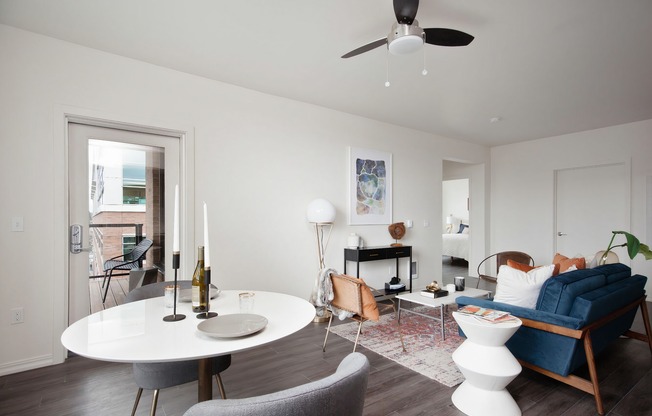 Living and dining room area with wood-inspired flooring and ceiling fan