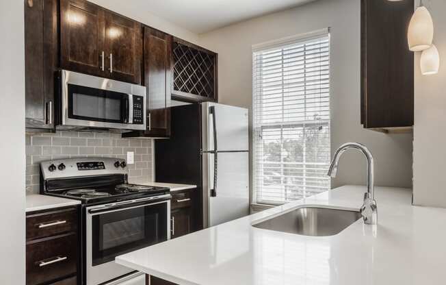 an empty kitchen with a sink and a refrigerator