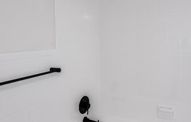 a bathroom with a white tub and a black shower curtain