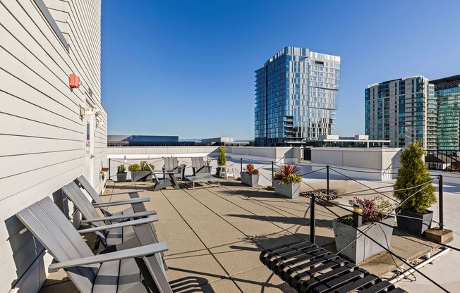 A patio with chairs and a table with a view of a cityscape.