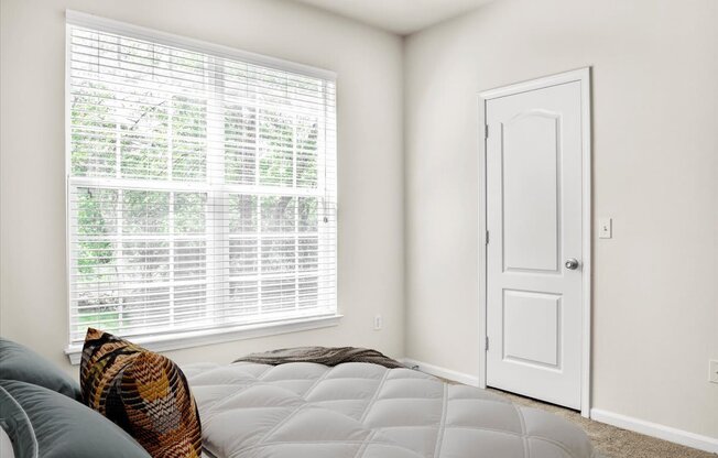 a bedroom with a bed and a large window