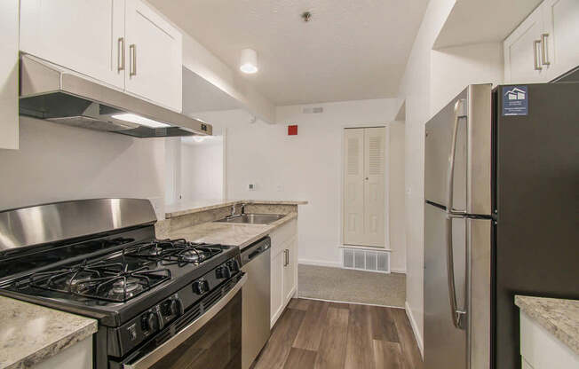 A kitchen with stainless steel appliances and white cabinets at West Hampton Park Apartments in Elkhorn, NE 68022