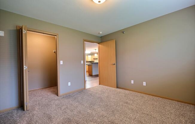 a bedroom with a closet and a door to a bathroom. Fargo, ND Urban Plains Apartments