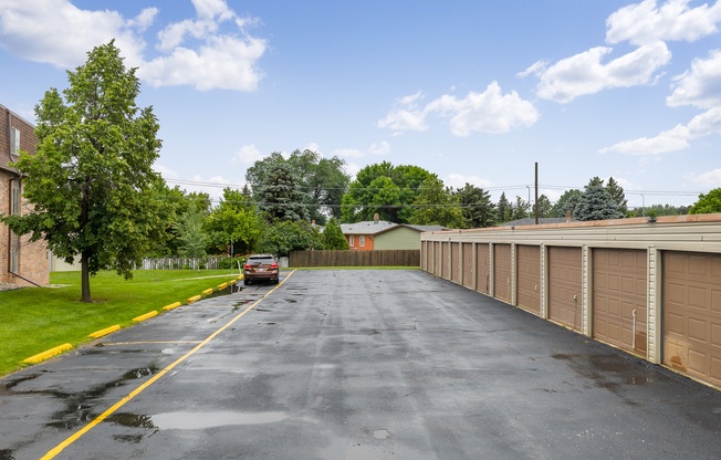A long driveway with a car parked at the end.