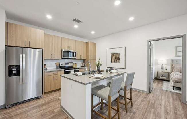 a kitchen with a large island and a stainless steel refrigerator