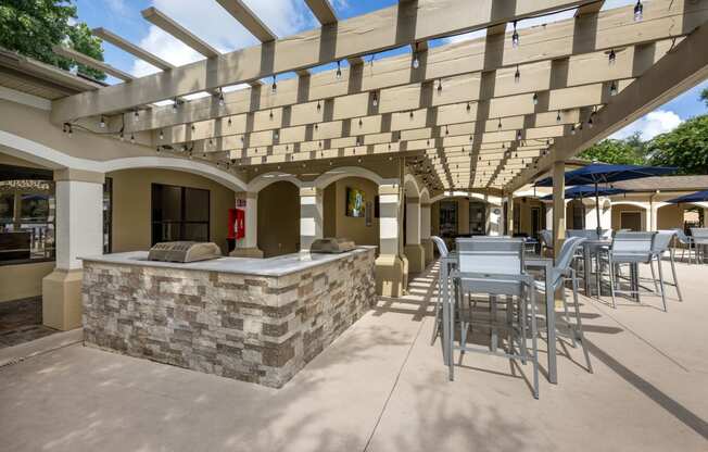 a patio with a bar and tables and chairs