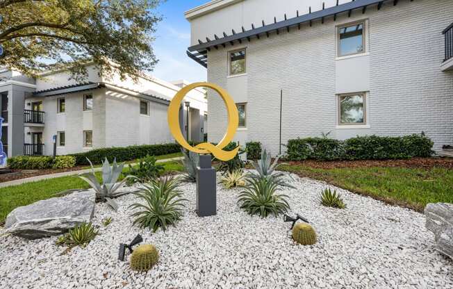a yard with a large yellow sculpture in front of a building