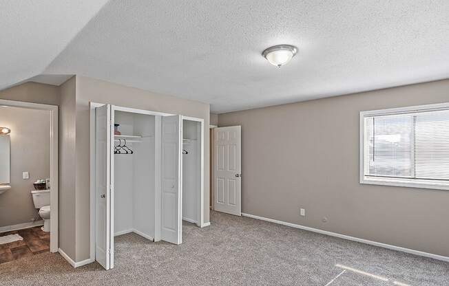 an empty bedroom with a toilet and a closet