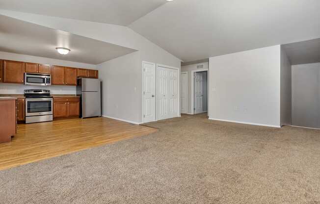 A spacious living room with a kitchen area in the background.