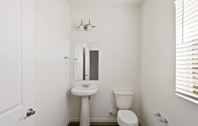 a bathroom with a toilet sink and mirror