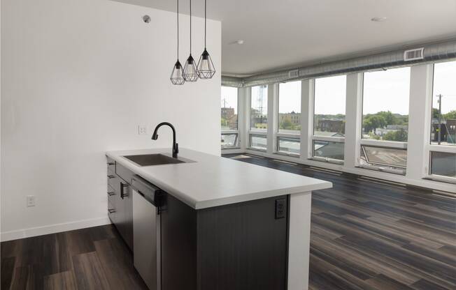 A kitchen with a large window and a large island with a sink and a faucet planat The Landing at 1001 NP, Fargo, North Dakota 58102