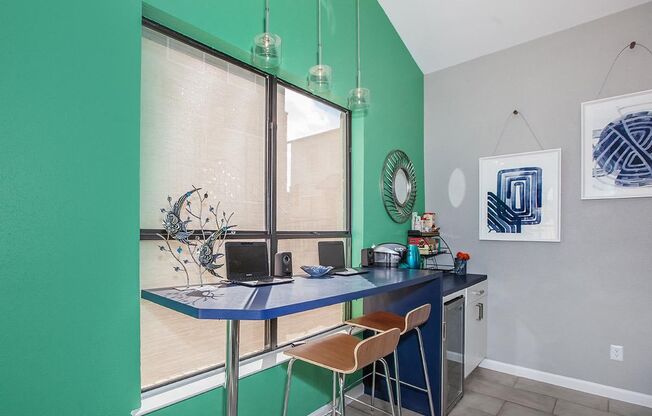 a green walled room with a desk and a window