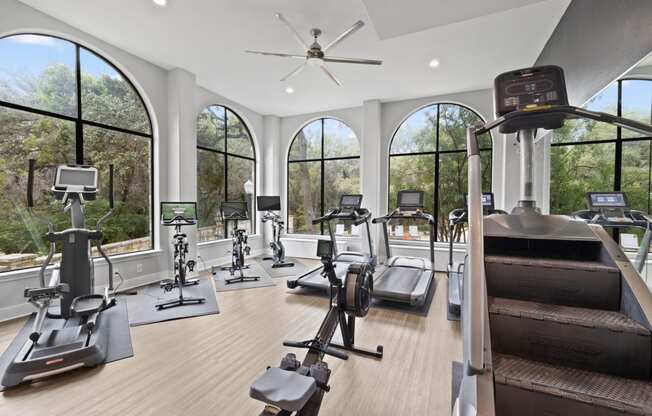 a gym with a row of windows and various exercise equipment