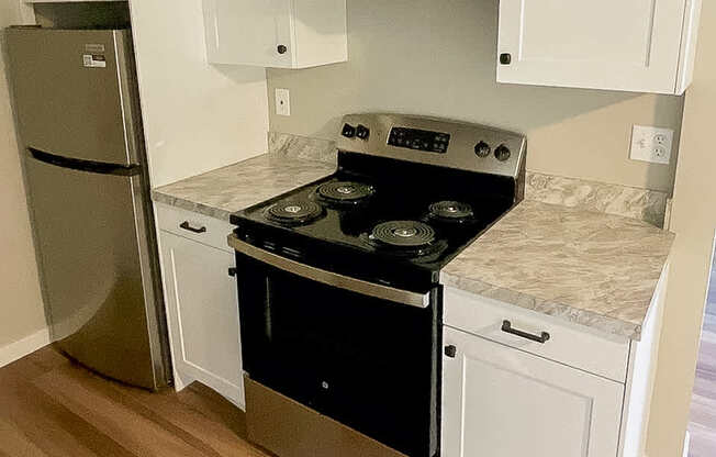 A kitchen with a stove top oven and a refrigerator.