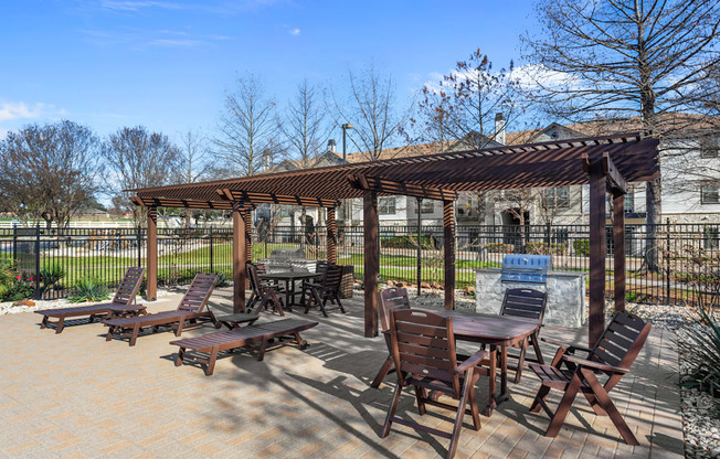 A patio with a table and chairs under a pergola.