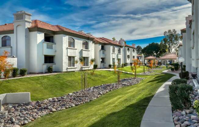 a row of houses with a sidewalk and grass