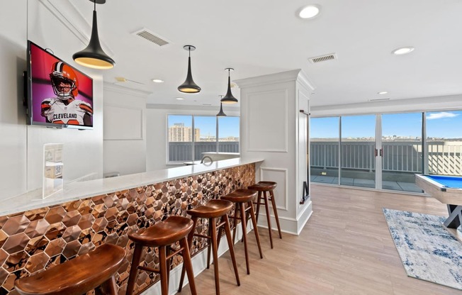 a bar with wooden stools in a room with a pool table