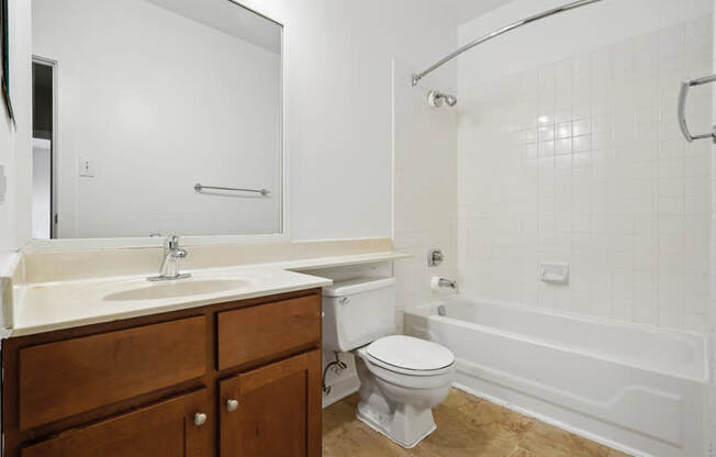 A white bathroom with a toilet, sink, and bathtub.